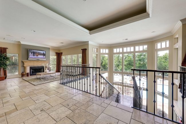 Hall featuring an upstairs landing, stone tile flooring, ornamental molding, a tray ceiling, and recessed lighting | Image 31