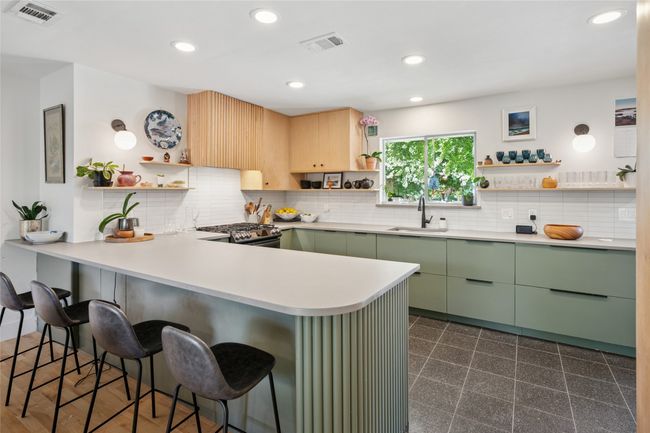 Designed for function and style, this kitchen includes a breakfast bar and ample quartz counters. | Image 9