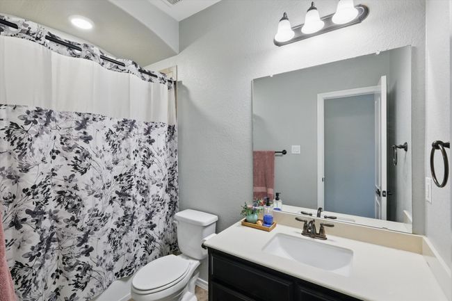 Full bathroom with vanity, a shower with curtain, and toilet | Image 25