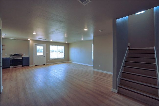 Unfurnished living room with stairway, light wood finished floors, and recessed lighting | Image 14