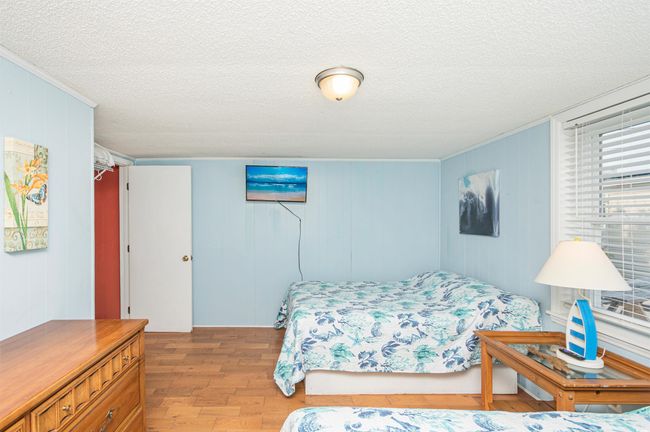 Bedroom with wood finished floors, crown molding, and a textured ceiling | Image 17