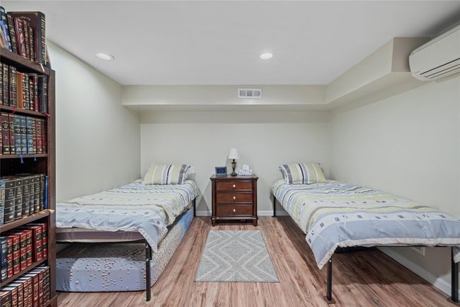 Bedroom featuring baseboards, visible vents, recessed lighting, a wall mounted air conditioner, and wood finished floors | Image 36