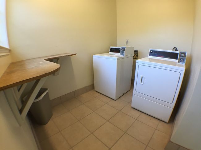 Shared laundry area featuring independent washer and dryer, baseboards, and light tile patterned floors | Image 12