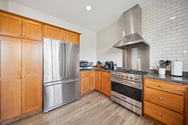 Beautiful kitchen with stainless steel appliances and a classic subway tile backsplash! | Image 14