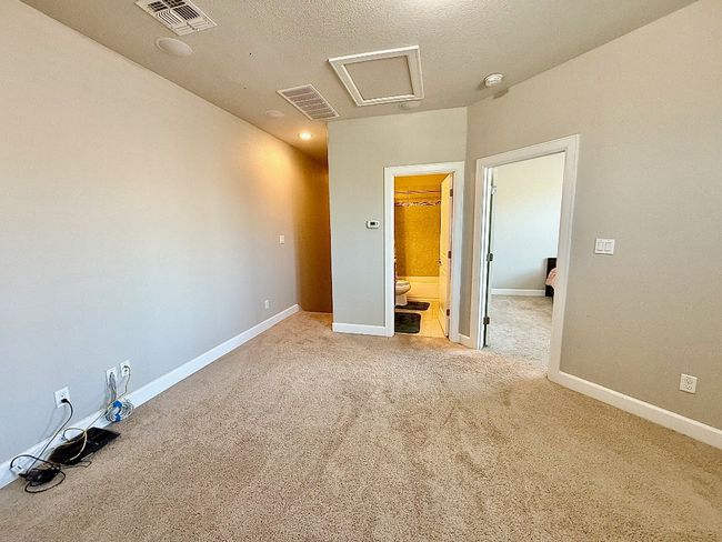 Unfurnished bedroom featuring attic access, carpet floors, baseboards, and a textured ceiling | Image 28