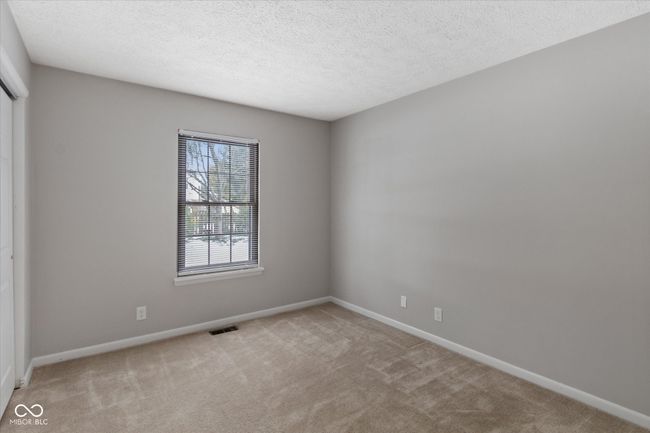 unfurnished bedroom with carpet floors, a textured ceiling, and a closet | Image 8