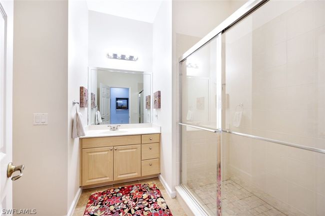 Bathroom with tile floors, an enclosed shower, and vanity | Image 24