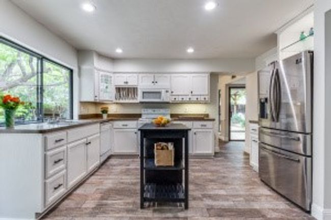 Kitchen featuring white appliances, a wealth of natural light, and white cabinetry | Image 15