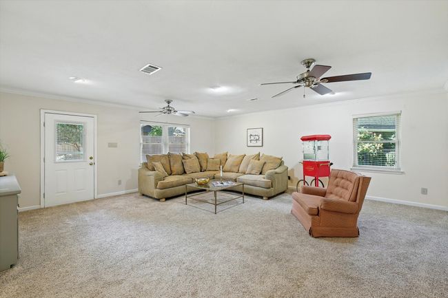 Living room with a ceiling fan, crown molding, and carpet floors | Image 17