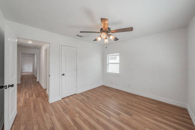 Unfurnished bedroom with light wood finished floors, baseboards, attic access, and ceiling fan | Image 27