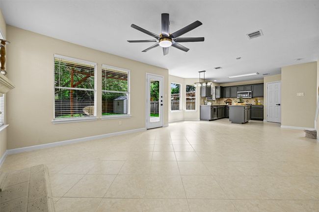 Unfurnished living room with a ceiling fan and light tile patterned floors | Image 13