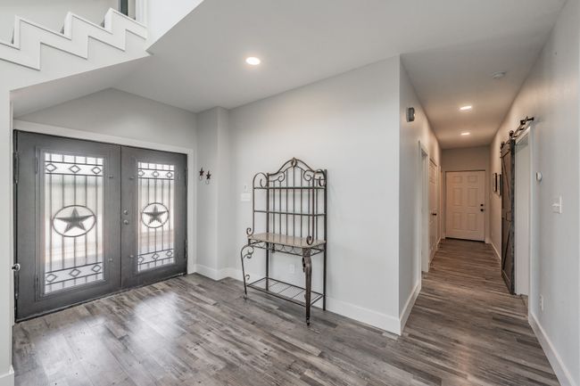Foyer entrance featuring french doors, wood finished floors, baseboards, recessed lighting, and a barn door | Image 17