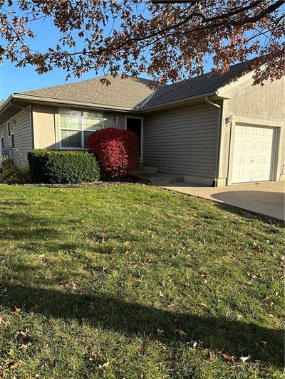 View of home's exterior with a garage and a lawn | Image 1