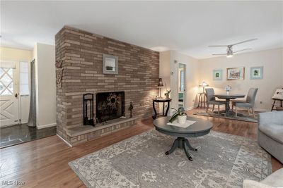 Gracious Living Room with custom stone hearth fireplace and dining area on the right. | Image 3