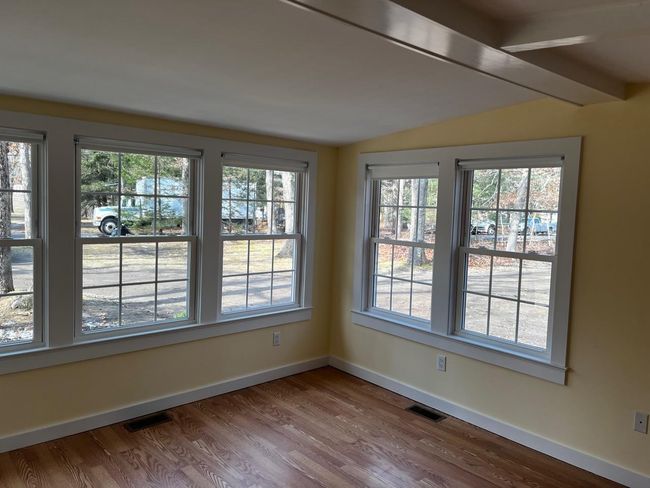Unfurnished dining area with baseboards, wood finished floors, visible vents, and vaulted ceiling | Image 5
