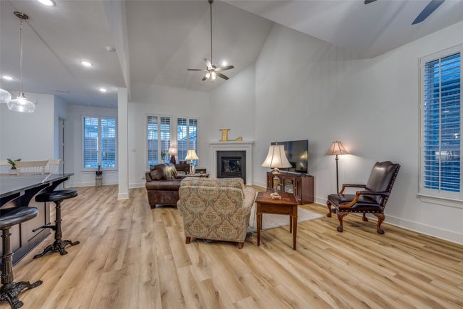 Living area featuring light wood-style floors, baseboards, and ceiling fan | Image 6