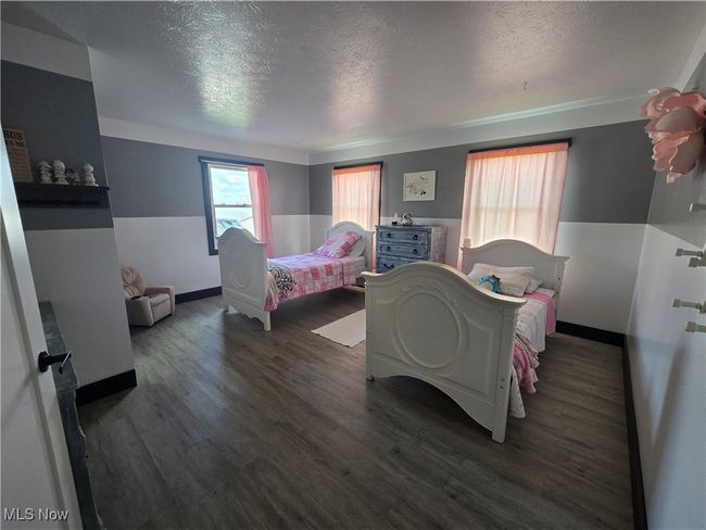 Bedroom with baseboards, wood finished floors, and a textured ceiling | Image 20