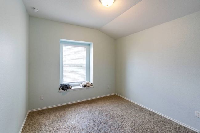 Unfurnished room featuring carpet floors, lofted ceiling, and a smoke detector | Image 12