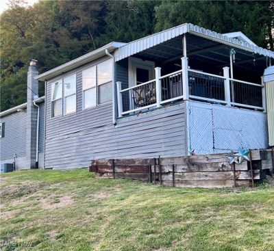 View of property exterior featuring a balcony, a lawn, and central AC | Image 2