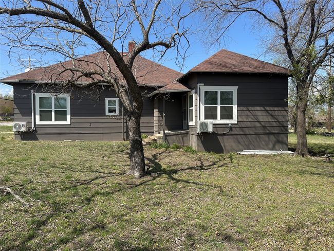 View of front facade featuring a chimney, a front lawn, ac unit, and roof with shingles | Image 4