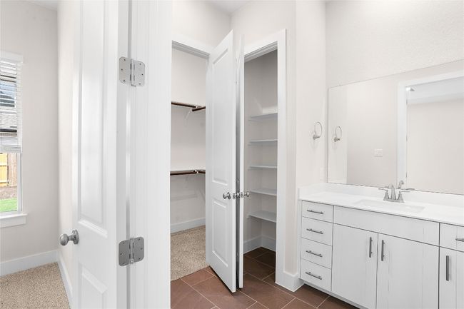 Bathroom with vanity, a spacious closet, baseboards, and tile patterned floors | Image 14