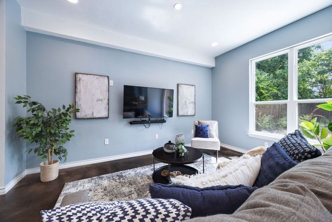 Natural light and recessed lighting create a warm, inviting space for relaxing or entertaining. | Image 8