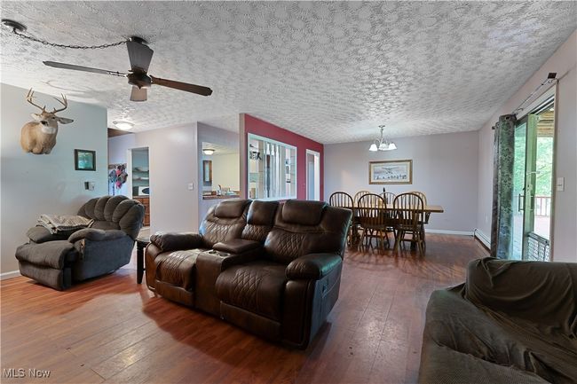 Living area with wood-style flooring, a chandelier, and ceiling fan | Image 14