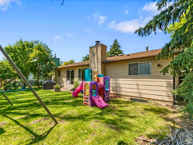 Rear view of property featuring a playground, a yard | Image 14