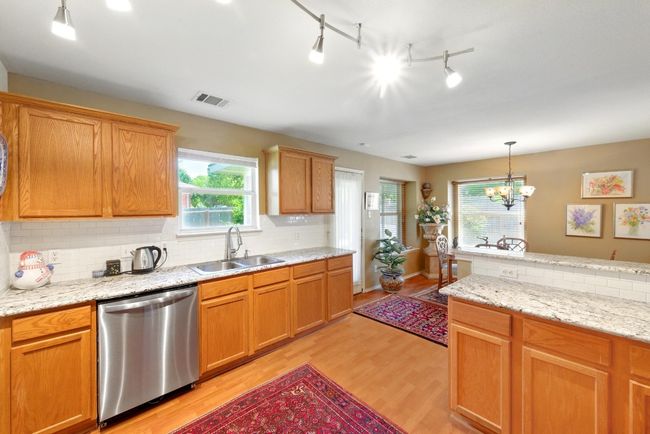 Kitchen featuring dishwasher, a sink, light wood-style flooring, decorative backsplash, and pendant lighting | Image 15