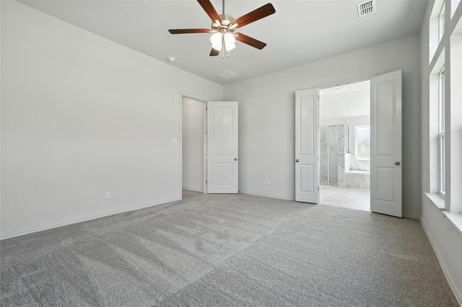 Unfurnished bedroom with carpet flooring, ensuite bath, and ceiling fan | Image 20