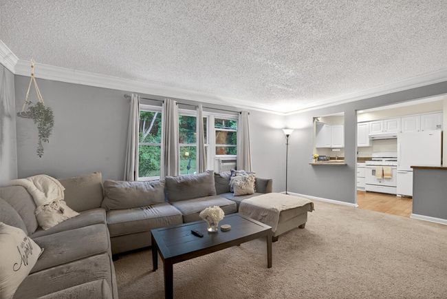 Living room with a textured ceiling, light carpet, and crown molding | Image 8