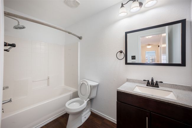 Full bath with wood finished floors, toilet, vanity, and shower / bathtub combination | Image 11