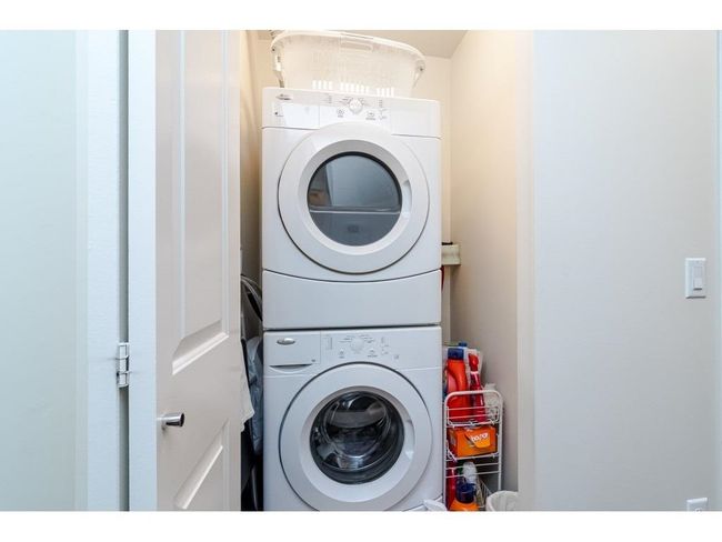 Washroom with stacked washer / drying machine and laundry area | Image 15