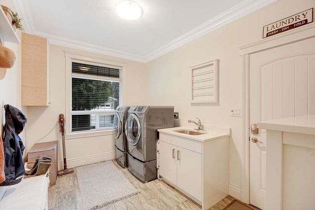 Laundry area featuring washer and clothes dryer, crown molding, and cabinet space | Image 25