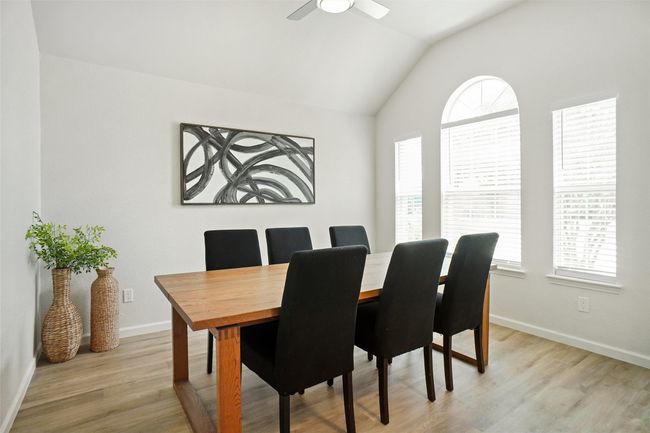 Dining room with healthy amount of natural light, lofted ceiling, light wood-style flooring, and baseboards | Image 12