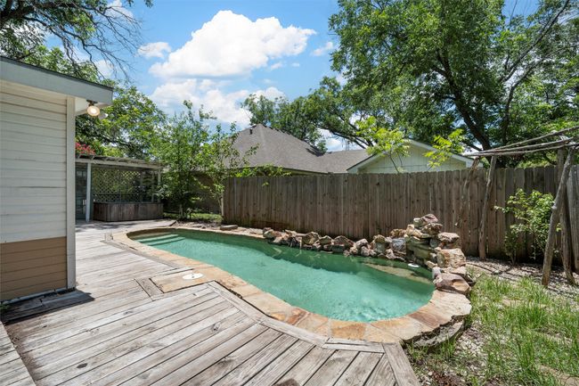 View of swimming pool with a deck and a fenced backyard | Image 25
