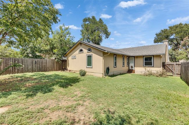 Back of property with a fenced backyard, roof with shingles, and a chimney | Image 17