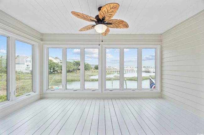 Unfurnished sunroom featuring a water view, plenty of natural light, and wooden ceiling | Image 12