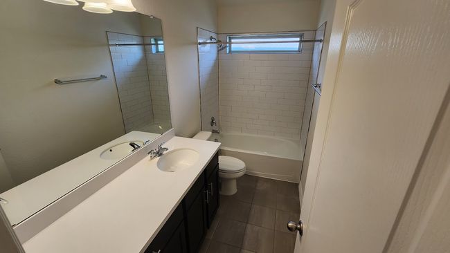 Full bathroom featuring toilet, tile patterned floors, vanity, and tub / shower combination | Image 26