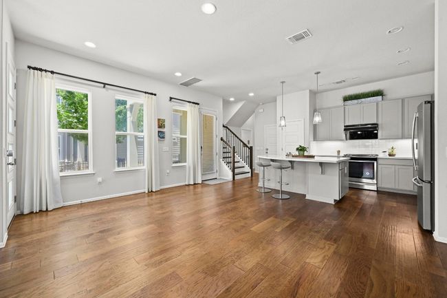 Kitchen featuring stainless steel appliances, a kitchen bar, recessed lighting, backsplash, and light countertops | Image 9