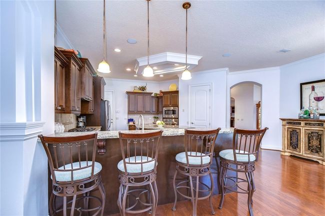 The spacious granite countertops and rich wooden cabinetry are perfect for culinary adventures or hosting friends around the chic breakfast bar. | Image 13