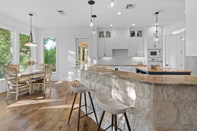 Kitchen featuring tasteful backsplash, white cabinetry | Image 9