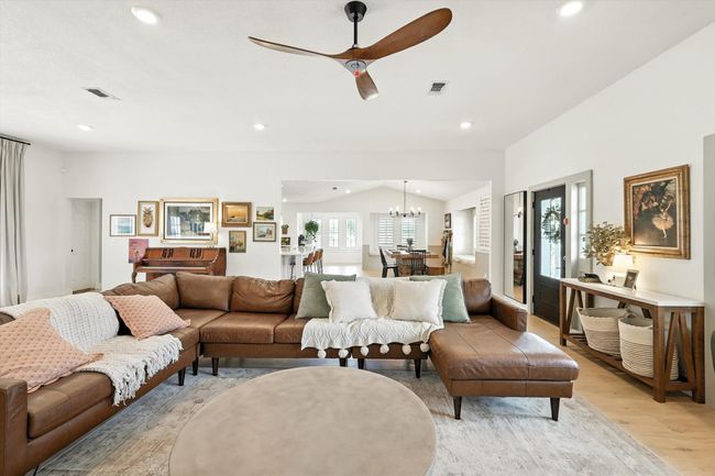 Living room with plenty of natural light, light wood-style floors, recessed lighting, vaulted ceiling, and a ceiling fan | Image 20