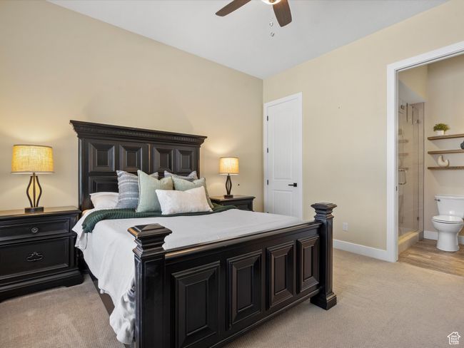 Bedroom featuring light colored carpet, baseboards, connected bathroom, and ceiling fan | Image 23