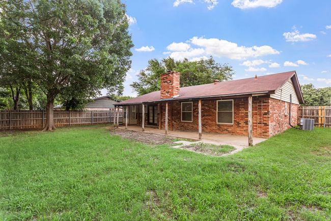 Back of house featuring a chimney, a patio area, a fenced backyard, and brick siding | Image 28