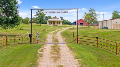 Family Homestead established in 1868. Electric gate with cattle guard with a driveway and old home that | Image 3