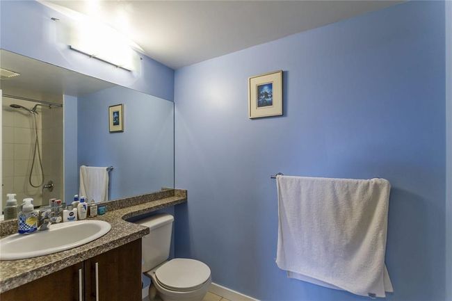 Bathroom with toilet, vanity, and a shower | Image 17