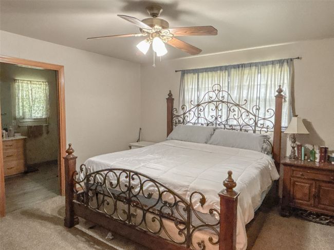 Carpeted bedroom with ceiling fan and multiple windows | Image 15