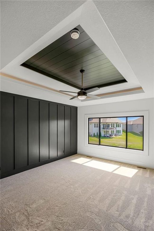 Unfurnished room featuring carpet flooring, ceiling fan, a tray ceiling, and a smoke detector | Image 18