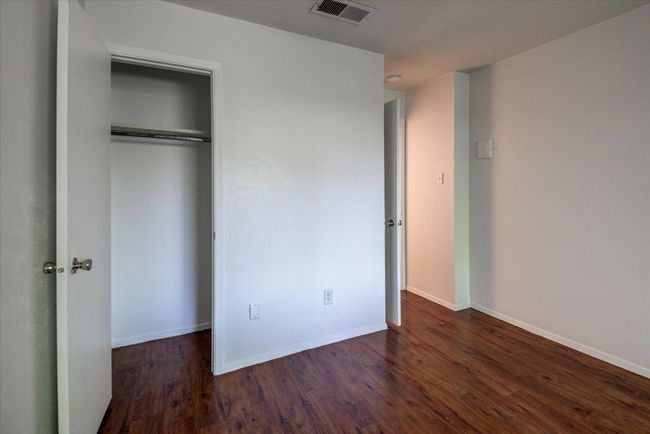 Unfurnished bedroom featuring visible vents, a closet, baseboards, and wood finished floors | Image 14